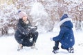 Woman and daughter playing in winter outdoor, mother and children having fun on snowy winter, throwing snowballs Royalty Free Stock Photo