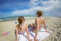 Woman and daughter relaxing on a beautiful beach together on vacation Royalty Free Stock Photo