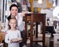 Woman with daughter standing with curbstone in store