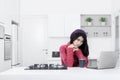 Woman daydreaming with laptop in the kitchen Royalty Free Stock Photo