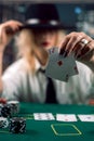 Woman dealer in hat with playing cards and poker chips in casino watching the game Royalty Free Stock Photo