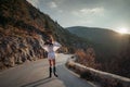 The woman is dear to the mountains. A woman in a white sweater, black boots and a hat walks along a winding alpine path Royalty Free Stock Photo