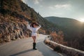 The woman is dear to the mountains. A woman in a white sweater, black boots and a hat walks along a winding alpine path Royalty Free Stock Photo