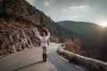 The woman is dear to the mountains. A woman in a white sweater, black boots and a hat walks along a winding alpine path Royalty Free Stock Photo