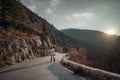 The woman is dear to the mountains. A woman in a white sweater, black boots and a hat walks along a winding alpine path Royalty Free Stock Photo