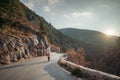 The woman is dear to the mountains. A woman in a white sweater, black boots and a hat walks along a winding alpine path Royalty Free Stock Photo