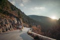 The woman is dear to the mountains. A woman in a white sweater, black boots and a hat walks along a winding alpine path Royalty Free Stock Photo