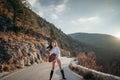 The woman is dear to the mountains. A woman in a white sweater, black boots and a hat walks along a winding alpine path Royalty Free Stock Photo