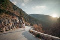 The woman is dear to the mountains. A woman in a white sweater, black boots and a hat walks along a winding alpine path Royalty Free Stock Photo