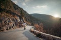 The woman is dear to the mountains. A woman in a white sweater, black boots and a hat walks along a winding alpine path Royalty Free Stock Photo