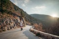 The woman is dear to the mountains. A woman in a white sweater, black boots and a hat walks along a winding alpine path Royalty Free Stock Photo