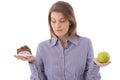 Woman debating cake or apple Royalty Free Stock Photo