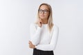 Woman decides how improve sales and income as posing in glasses and office outfit over white background looking away