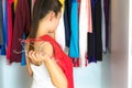 Woman deciding on what to wear in front of her closet Royalty Free Stock Photo