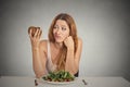 Woman deciding whether to eat healthy food or sweet cookies Royalty Free Stock Photo