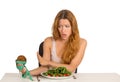 Woman deciding whether to eat healthy food or sweet cookies Royalty Free Stock Photo