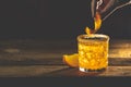 Woman decorat Orange Twist alcoholic cocktail negroni on a old wooden board. Drink with gin, campari martini rosso and orange, an Royalty Free Stock Photo