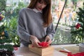 Woman decorate xmas gift box with ribbon. season greetings for w Royalty Free Stock Photo