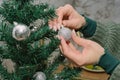 Woman decorates christmas tree. Hands hanging ornaments on a Christmas tree Royalty Free Stock Photo