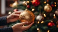 Woman decorates a Christmas tree and hangs a shiny ball on it. Generative Ai