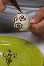 A woman decorates with the help of dark chocolate popcake glazed with white chocolate Royalty Free Stock Photo