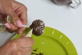 A woman decorates with the help of white chocolate popcake glazed with dark chocolate Royalty Free Stock Photo