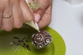 A woman decorates with the help of white chocolate popcake glazed with dark chocolate Royalty Free Stock Photo