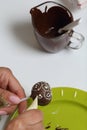 A woman decorates with the help of white chocolate popcake glazed with dark chocolate Royalty Free Stock Photo