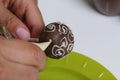 A woman decorates with the help of white chocolate popcake glazed with dark chocolate Royalty Free Stock Photo