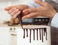 woman is decorating the cake with chocolate, hands close up