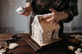 Woman decorating Christmas gingerbread house