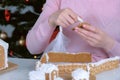 Woman is decorating christmas gingerbread man cookie with sugar sweet icing. Royalty Free Stock Photo