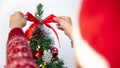 Woman decorating christmas tree with red bow in room house. Merry christmas Royalty Free Stock Photo