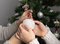 Woman decorating christmas tree.White Christmas ball in hands of girls on background of Christmas tree Royalty Free Stock Photo