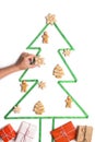Woman decorating Creative 2020 Christmas tree with gingerbreads