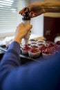 Woman decorating cupcakes with raspberry frosting Royalty Free Stock Photo