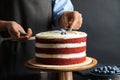 Woman decorating delicious homemade red velvet cake Royalty Free Stock Photo