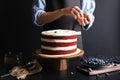 Woman decorating delicious homemade red velvet cake Royalty Free Stock Photo