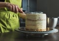 woman decorating a delicious layered sponge cake with icing cream Royalty Free Stock Photo