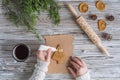 Woman decorating honey gingerbread cookies in a form of christmas tree on wooden grey table and craft paper. Royalty Free Stock Photo