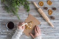 Woman decorating honey gingerbread cookies in a form of christmas tree on wooden grey table and craft paper. Royalty Free Stock Photo
