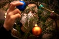 Woman is decoration a christmas tree with baubles while she wearing a face mask, corona Royalty Free Stock Photo