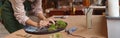 Focused woman decorator making green ikebana on tray with epoxy resin in florist workshop