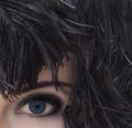 Woman with deep blue eyes in black feather headdress. Smoky eyes make-up.