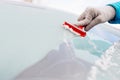 Woman deicing front car windshield with scraper Royalty Free Stock Photo