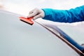 Woman deicing front car windshield with scraper Royalty Free Stock Photo