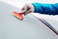 Woman deicing front car windshield with scraper Royalty Free Stock Photo