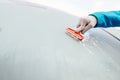 Woman deicing front car windshield with scraper Royalty Free Stock Photo