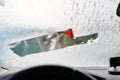 Woman deicing front car windshield with scraper Royalty Free Stock Photo