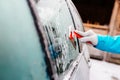Woman deicing side car windshield with scraper Royalty Free Stock Photo